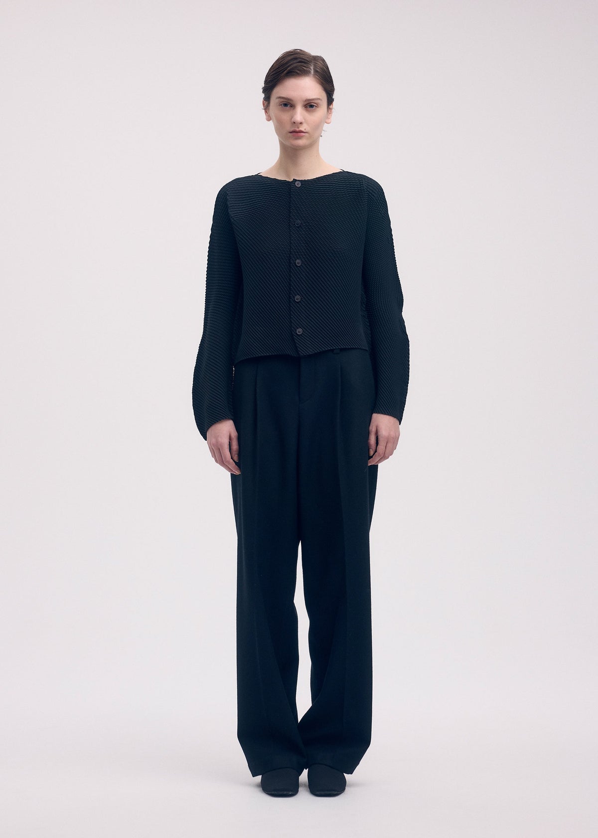A model wears the Issey Miyake SHIFTED MISTY PLEATS cardigan.