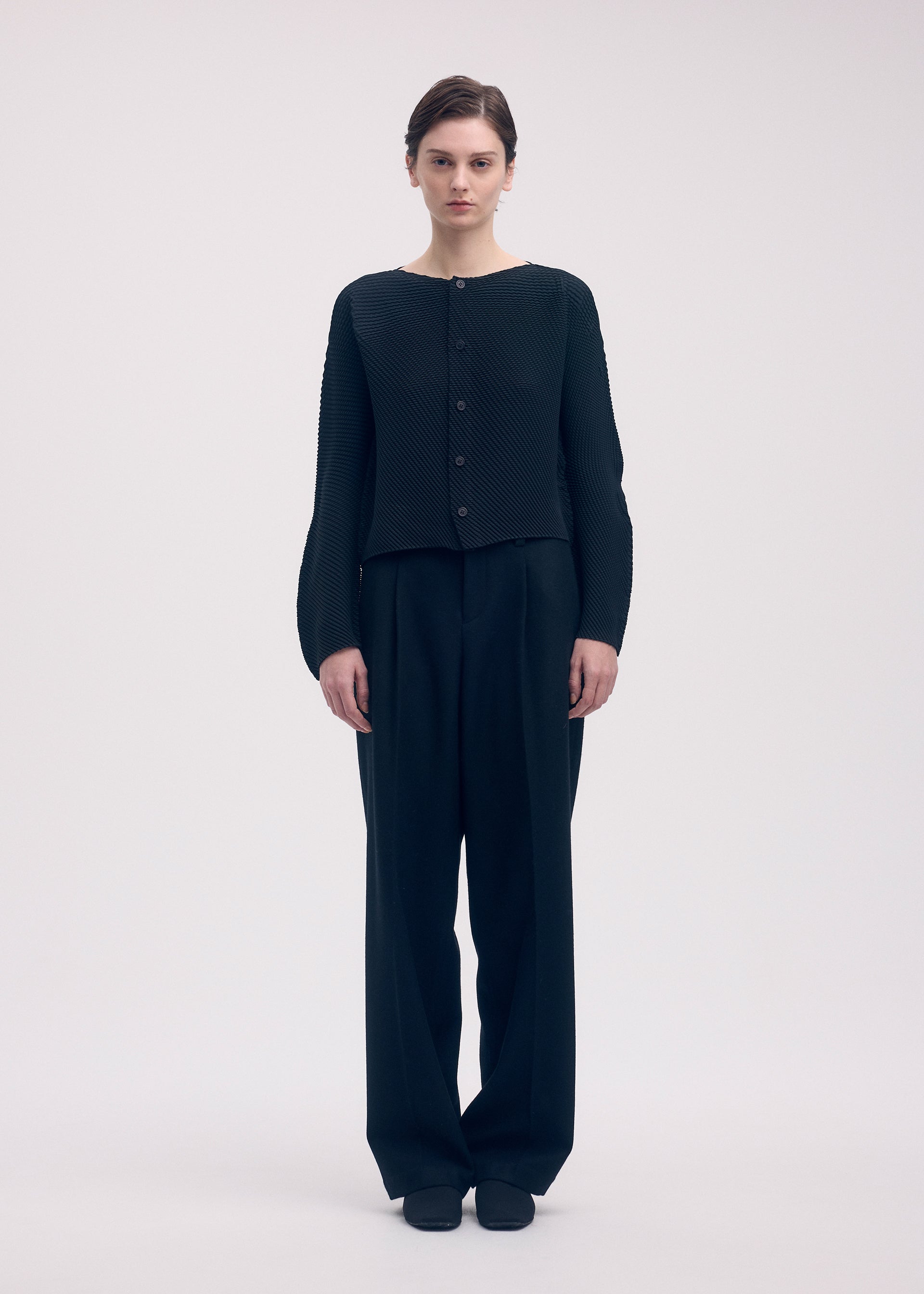 A model wears the Issey Miyake SHIFTED MISTY PLEATS cardigan.