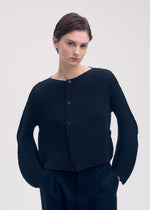 A model wears the Issey Miyake SHIFTED MISTY PLEATS cardigan.