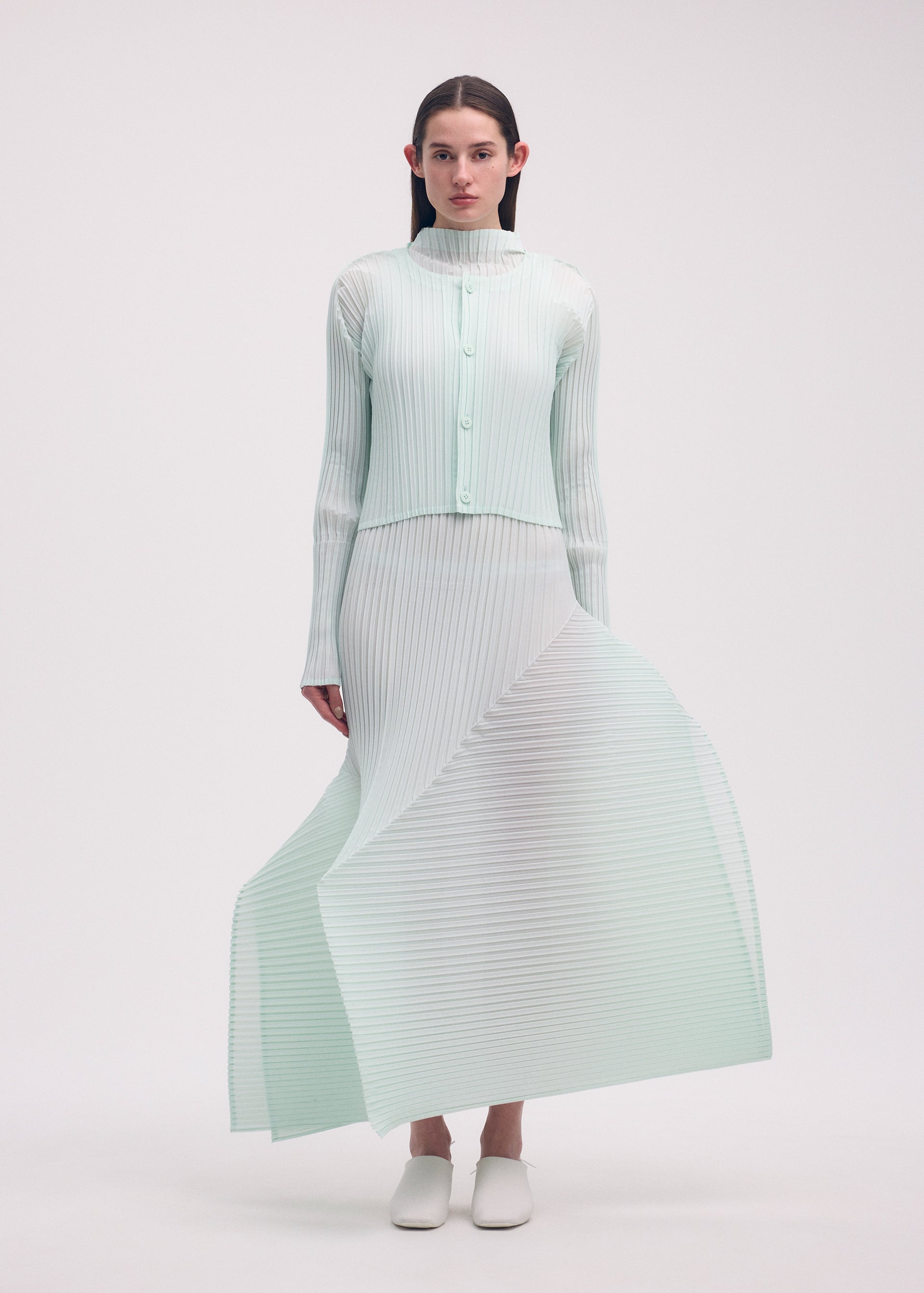 A model wears the ISSEY MIYAKE FOLD PLEATS cardigan.