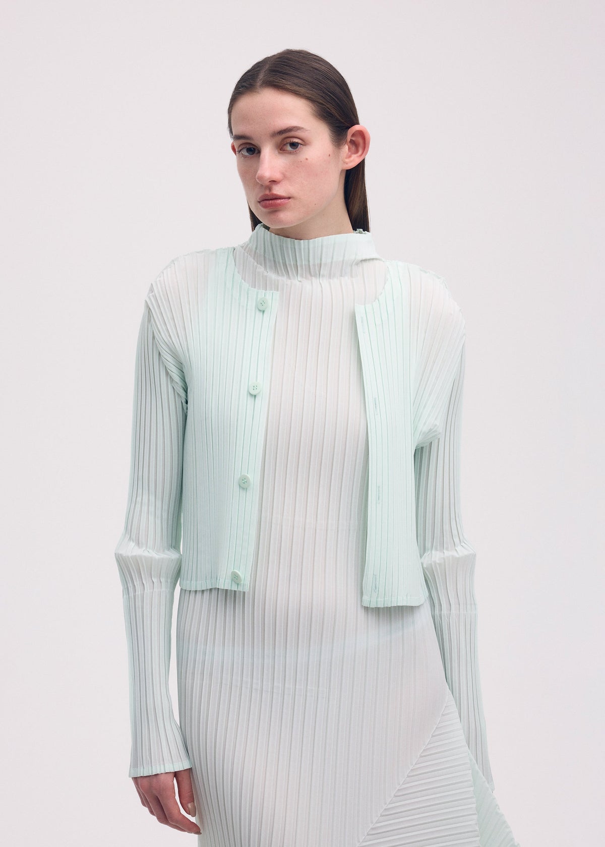 A model wears the ISSEY MIYAKE FOLD PLEATS cardigan.