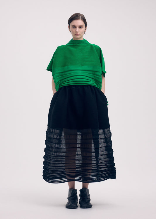 A model wears the Issey Miyake MOVING KNIT skirt.