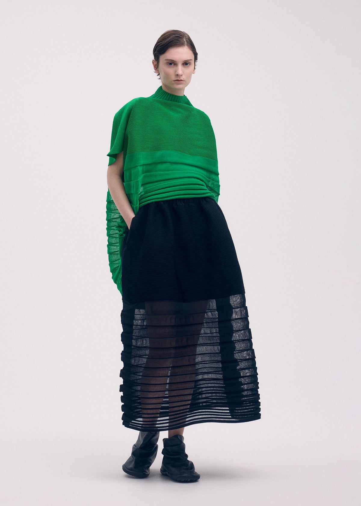 A model wears the Issey Miyake MOVING KNIT skirt.