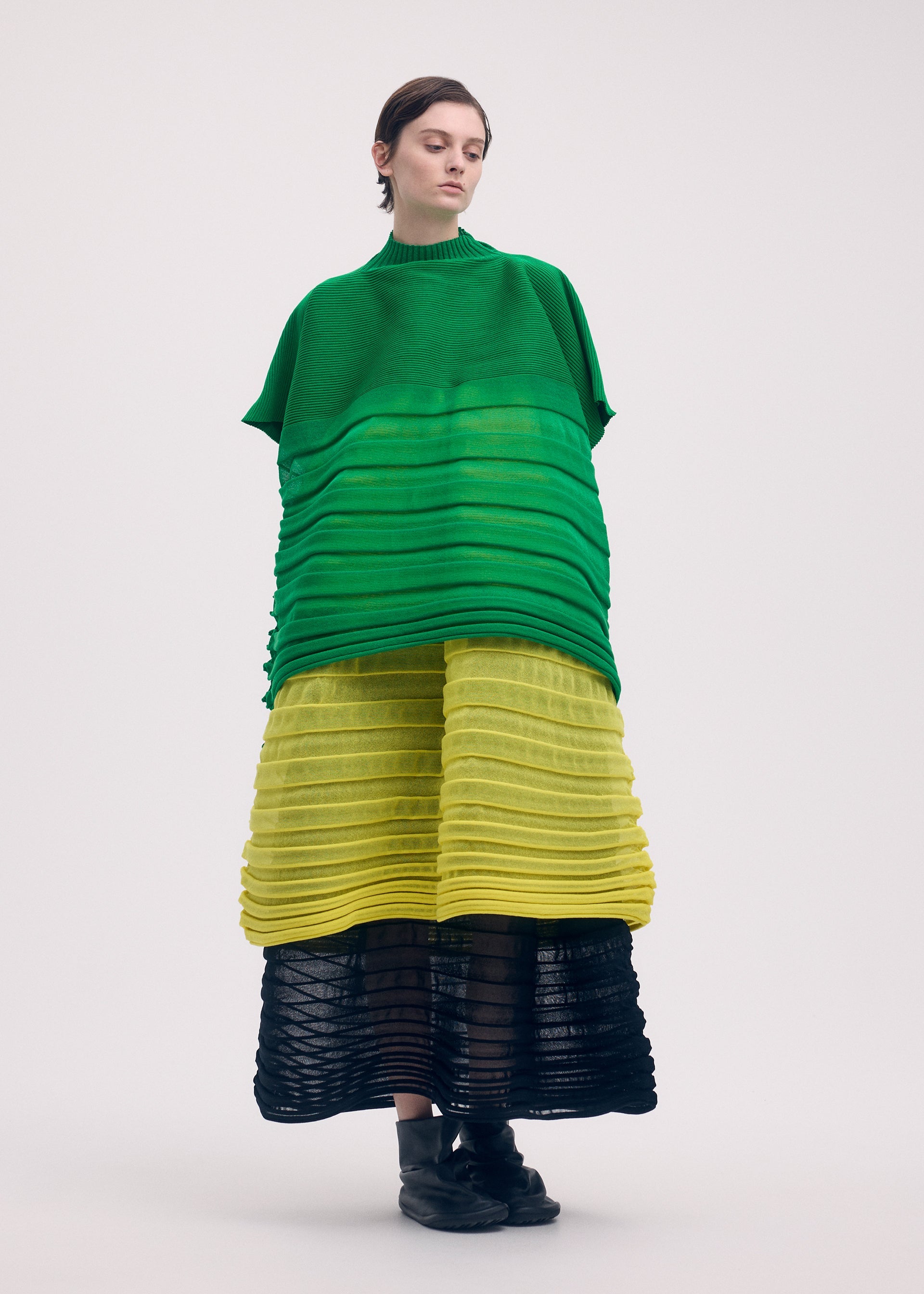 A model wears the Issey Miyake MOVING KNIT skirt.