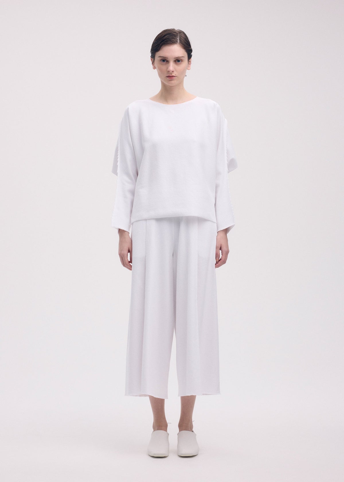 A model wears the ISSEY MIYAKE CAMPAGNE top.