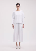 A model wears the ISSEY MIYAKE CAMPAGNE top.