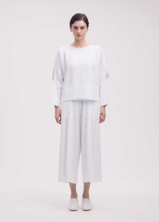 A model wears the ISSEY MIYAKE CAMPAGNE top.