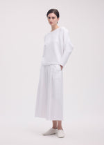 A model wears the ISSEY MIYAKE CAMPAGNE top.