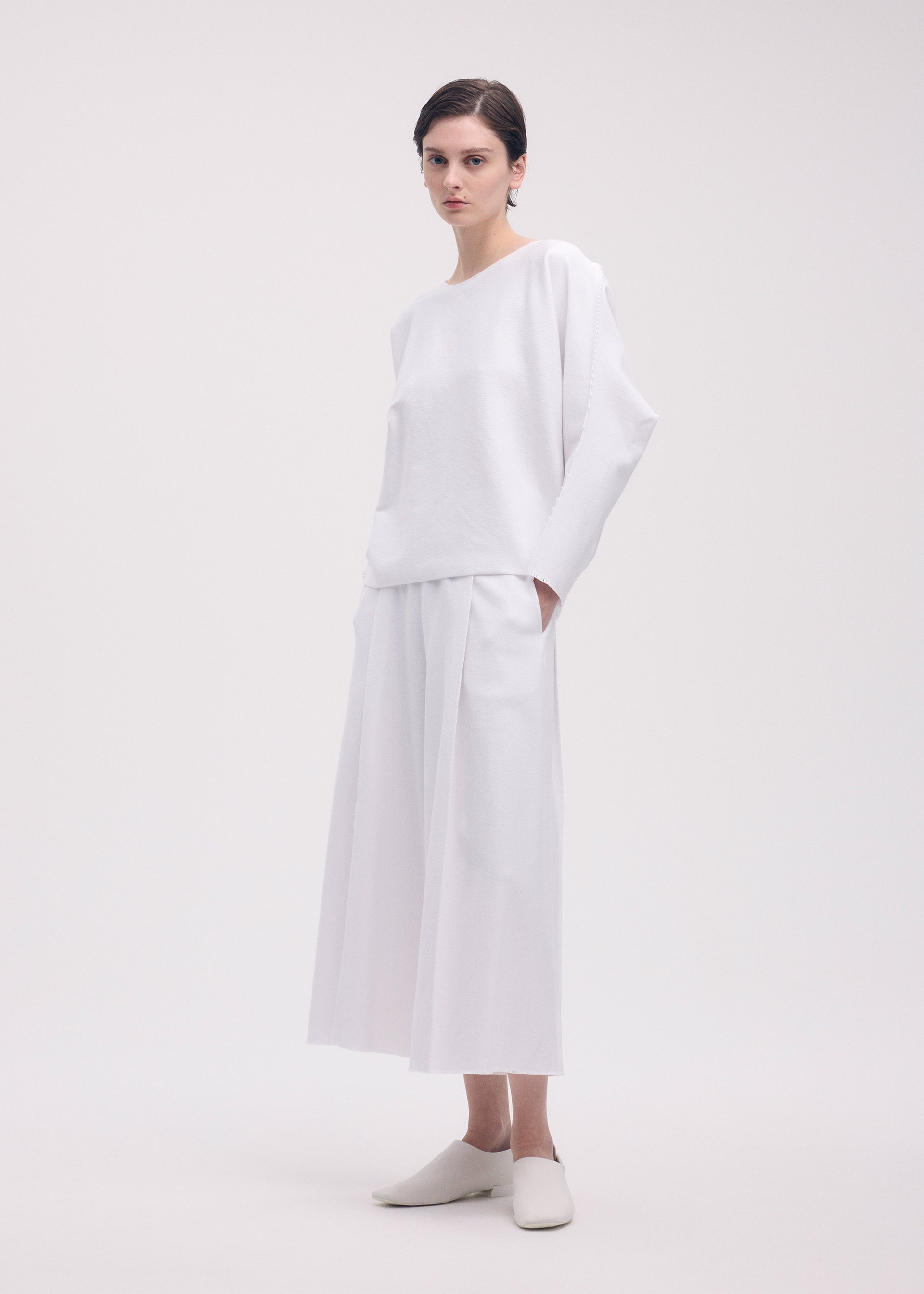 A model wears the ISSEY MIYAKE CAMPAGNE top.