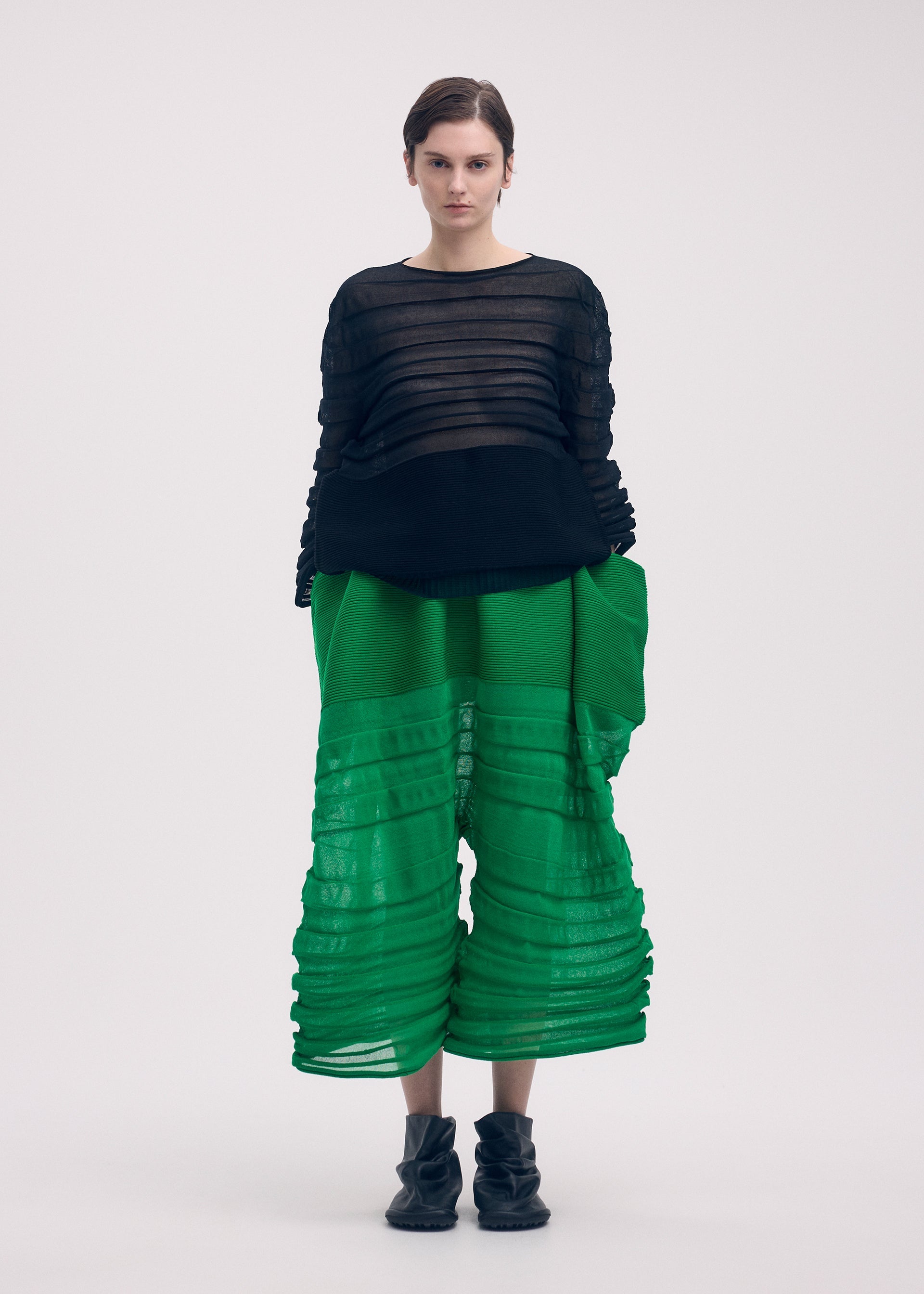 A model wears the Issey Miyake MOVING KNIT top.
