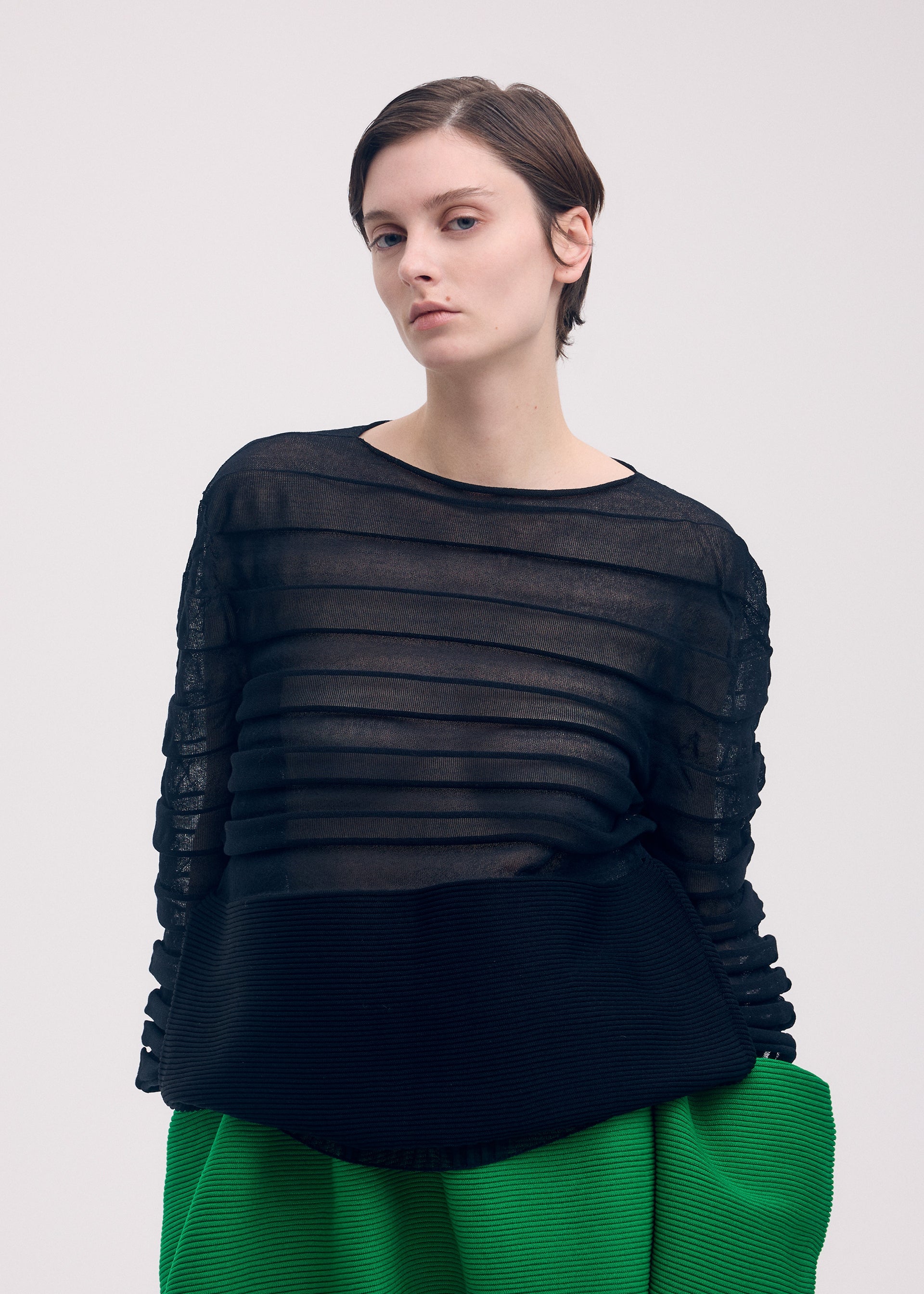 A model wears the Issey Miyake MOVING KNIT top.