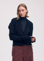 A model wears the ISSEY MIYAKE DISPLACED KNIT cardigan.