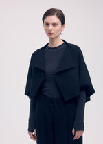 A model wears the ISSEY MIYAKE CAMPAGNE cardigan.