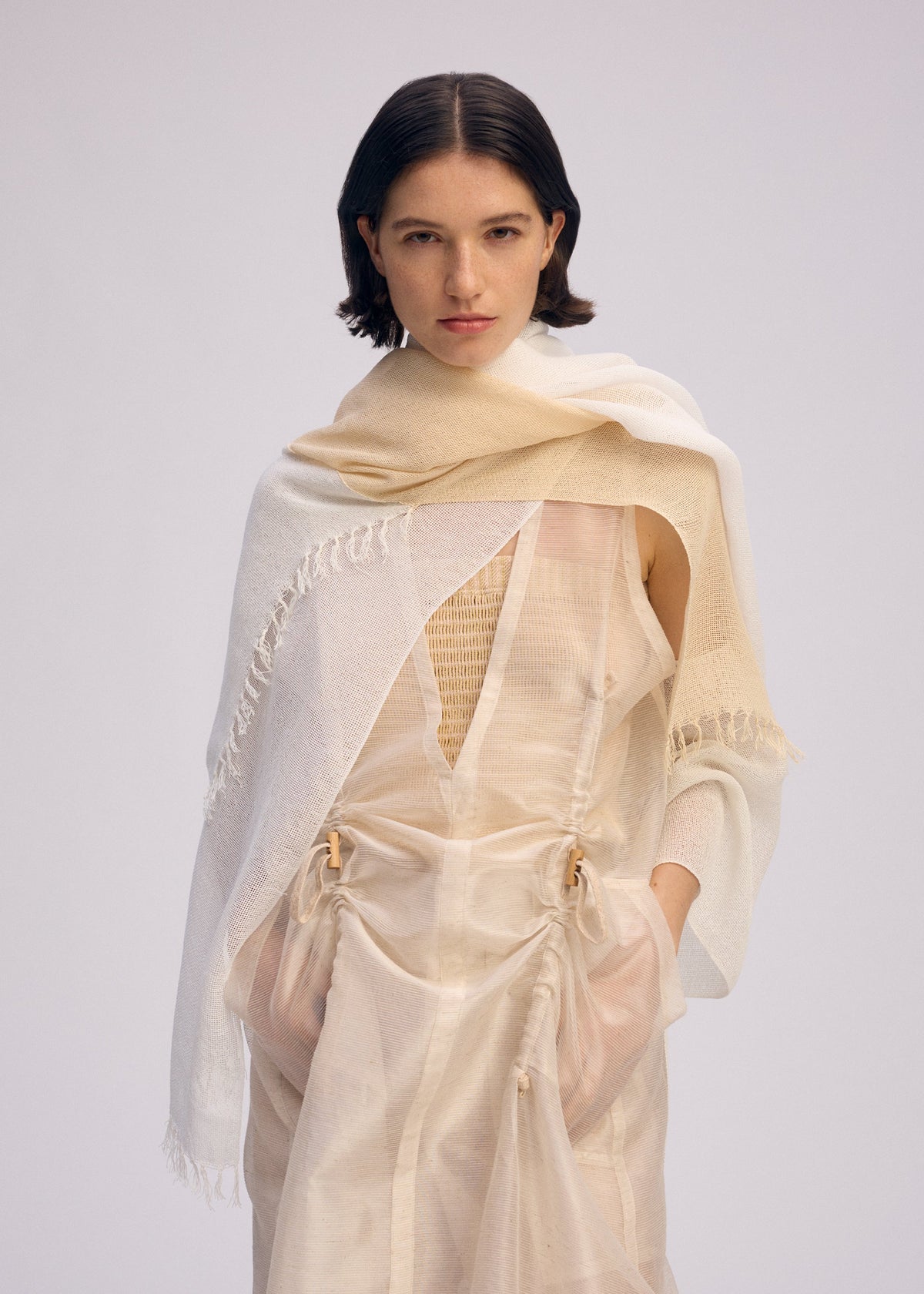 A model wears the ISSEY MIYAKE SLITS STOLE stole.