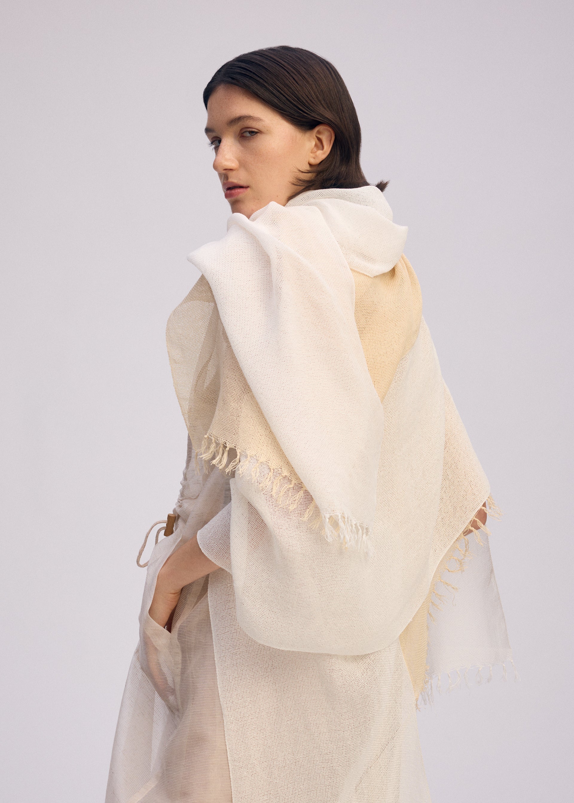 A model wears the ISSEY MIYAKE SLITS STOLE stole.
