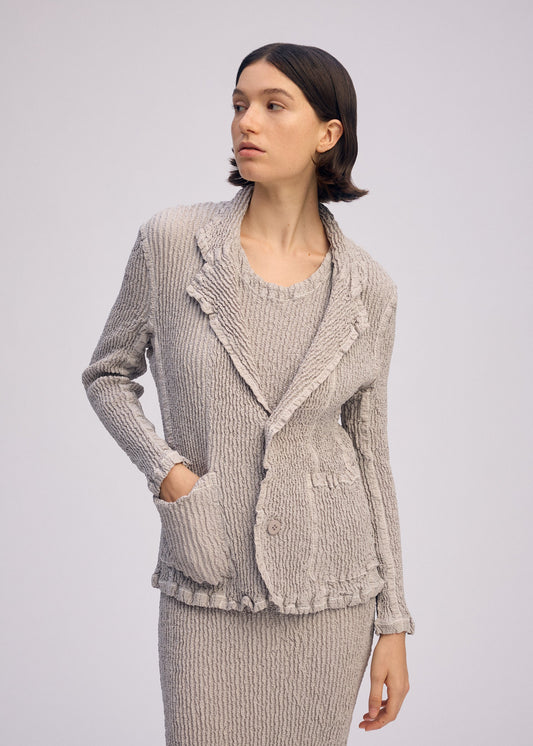A model wears the ISSEY MIYAKE WAVELET ENSEMBLE jacket.