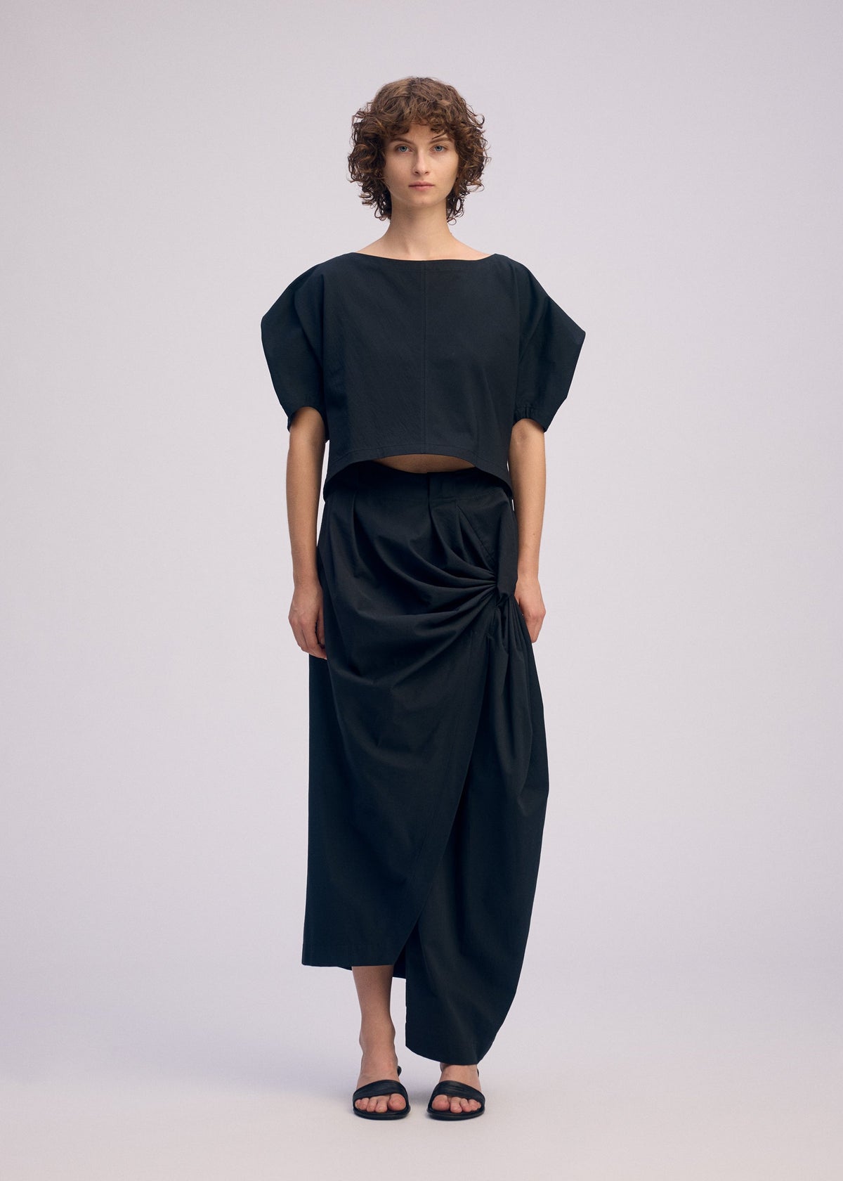 A model wears the ISSEY MIYAKE TWISTED DRAPE pants.