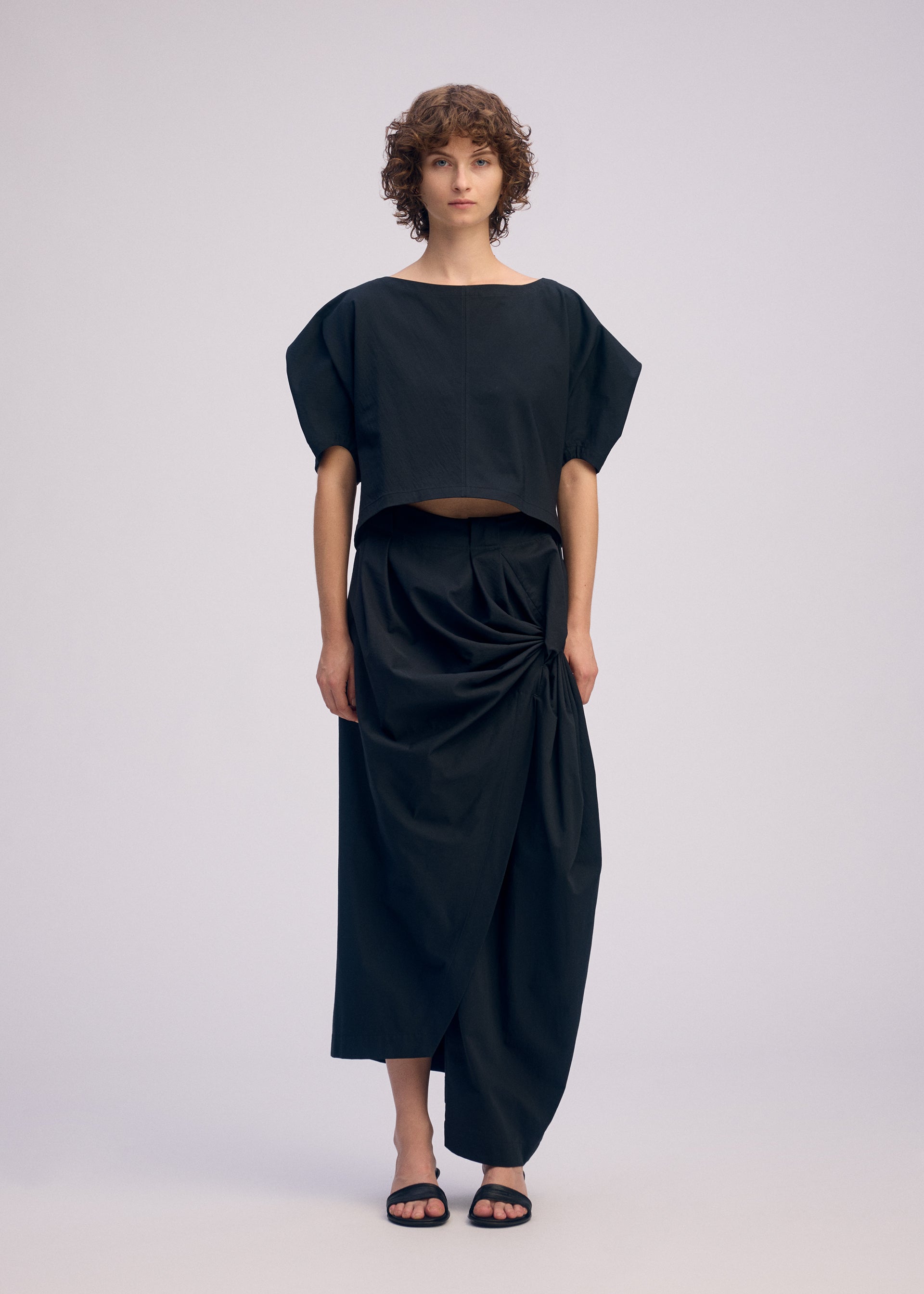 A model wears the ISSEY MIYAKE TWISTED DRAPE pants.