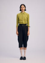 A model wears the Issey Miyake BELTED WOOL PANTS prêt à porter.