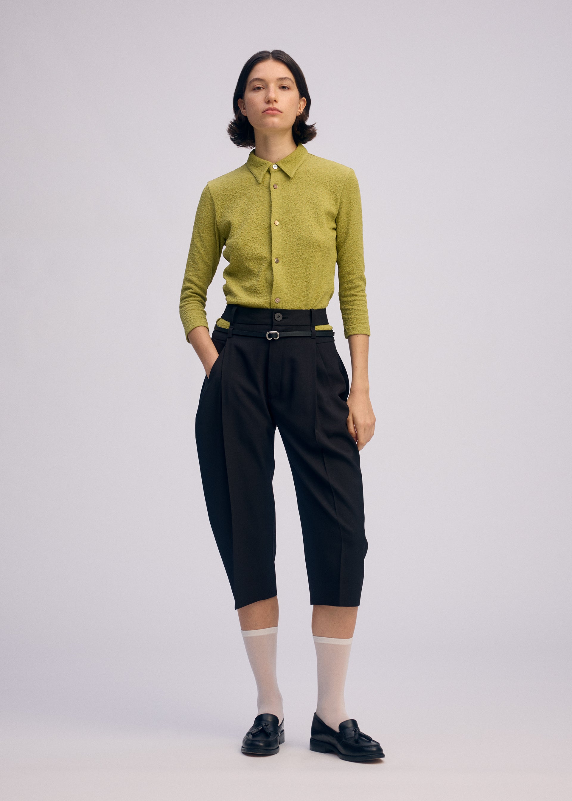 A model wears the Issey Miyake BELTED WOOL PANTS prêt à porter.