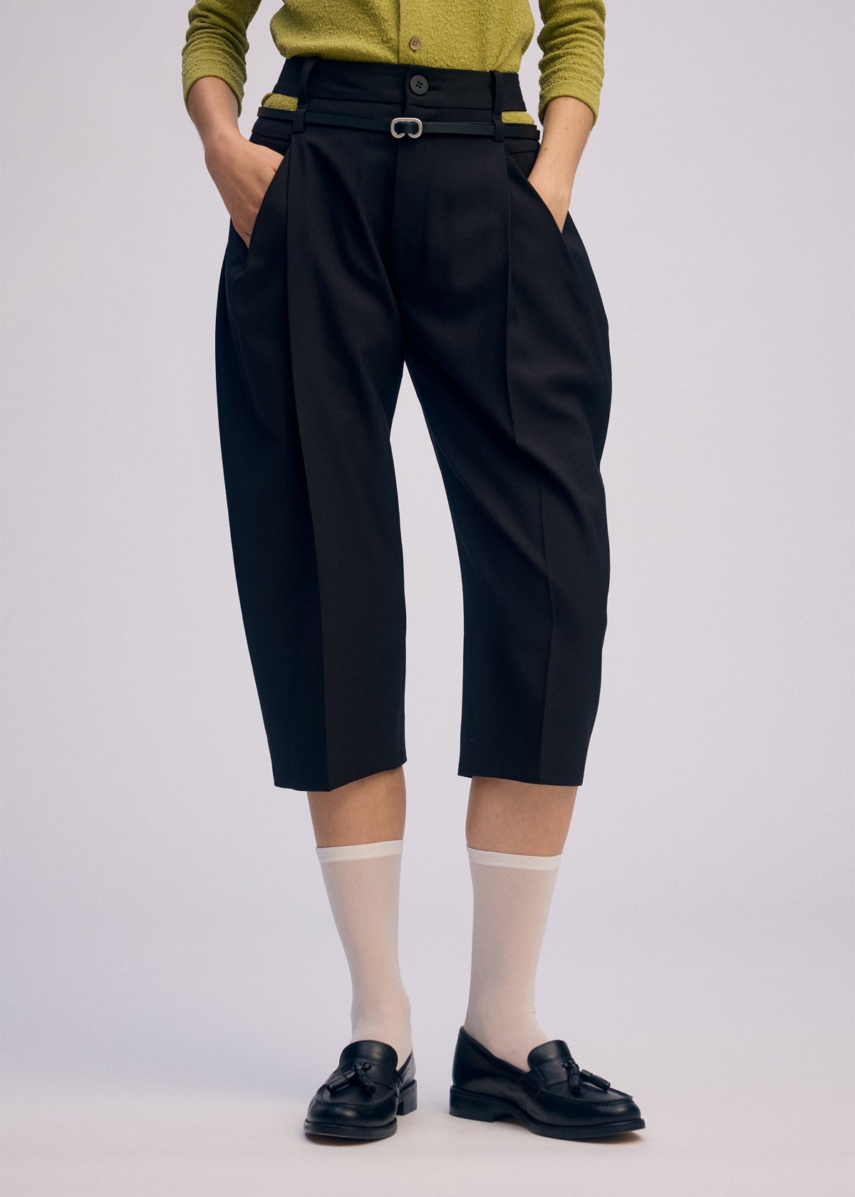 A model wears the Issey Miyake BELTED WOOL PANTS prêt à porter.