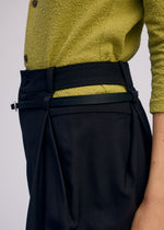 A model wears the Issey Miyake BELTED WOOL PANTS prêt à porter.
