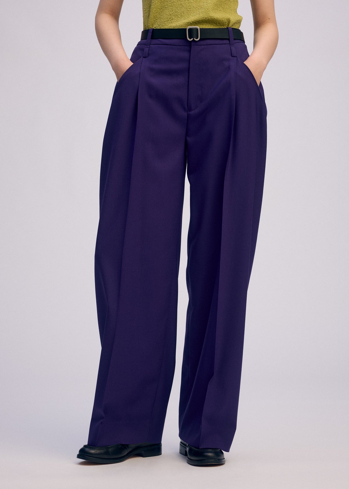 A model wears the Issey Miyake BELTED WOOL PANTS prêt à porter.