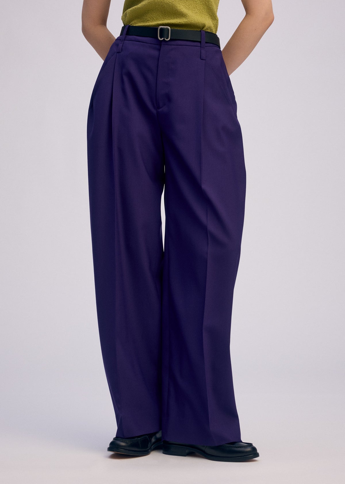 A model wears the Issey Miyake BELTED WOOL PANTS prêt à porter.