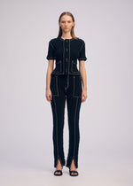 A model wears the ISSEY MIYAKE WAVELET ENSEMBLE pants.
