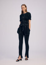 A model wears the ISSEY MIYAKE WAVELET ENSEMBLE pants.