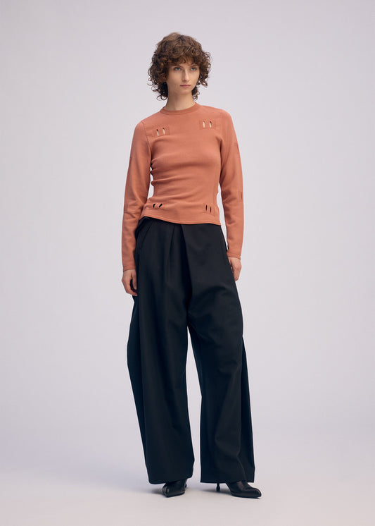 A model wears the ISSEY MIYAKE FLUTTERING PANTS pants.