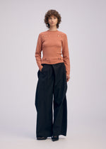 A model wears the ISSEY MIYAKE FLUTTERING PANTS pants.