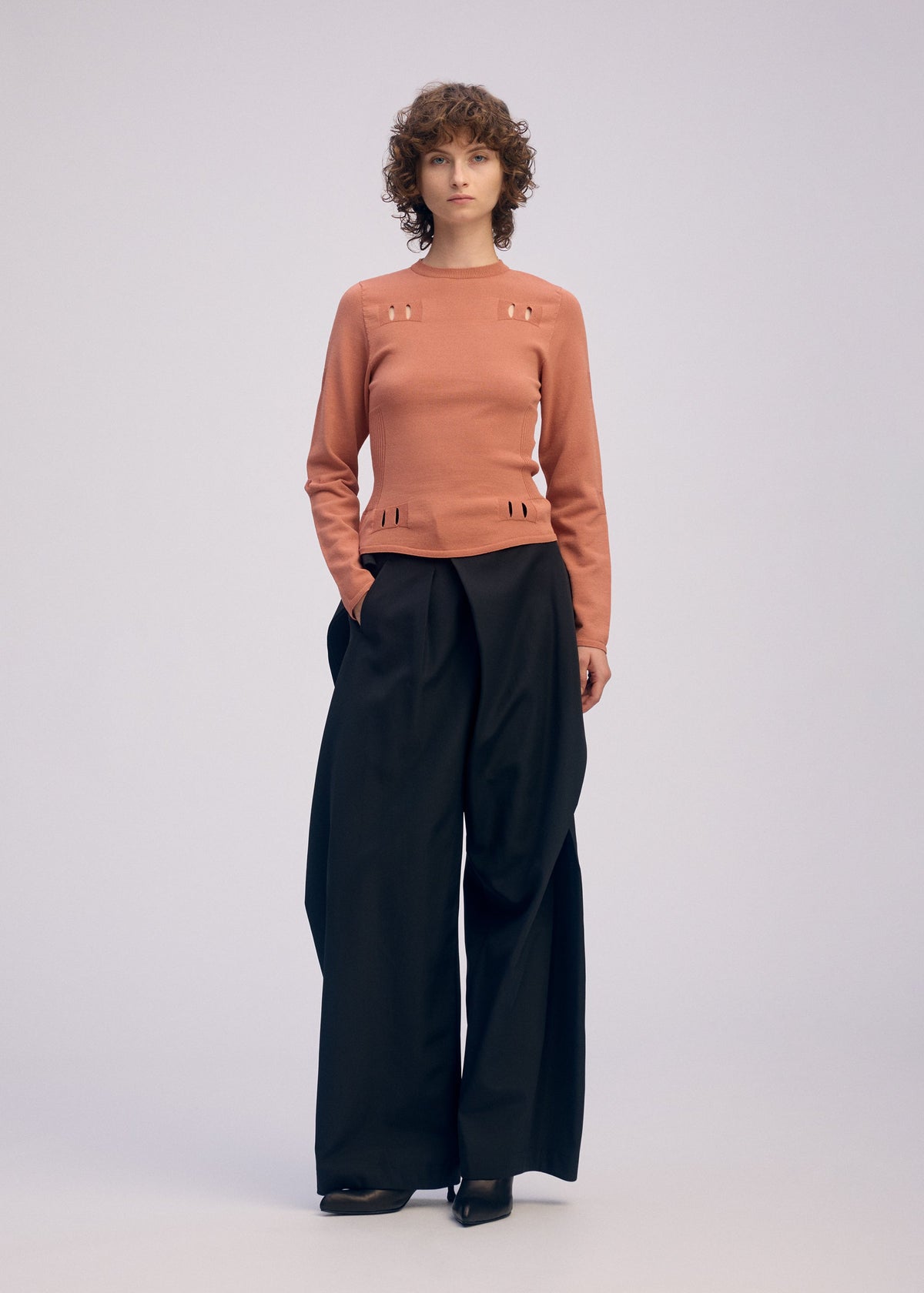 A model wears the ISSEY MIYAKE FLUTTERING PANTS pants.