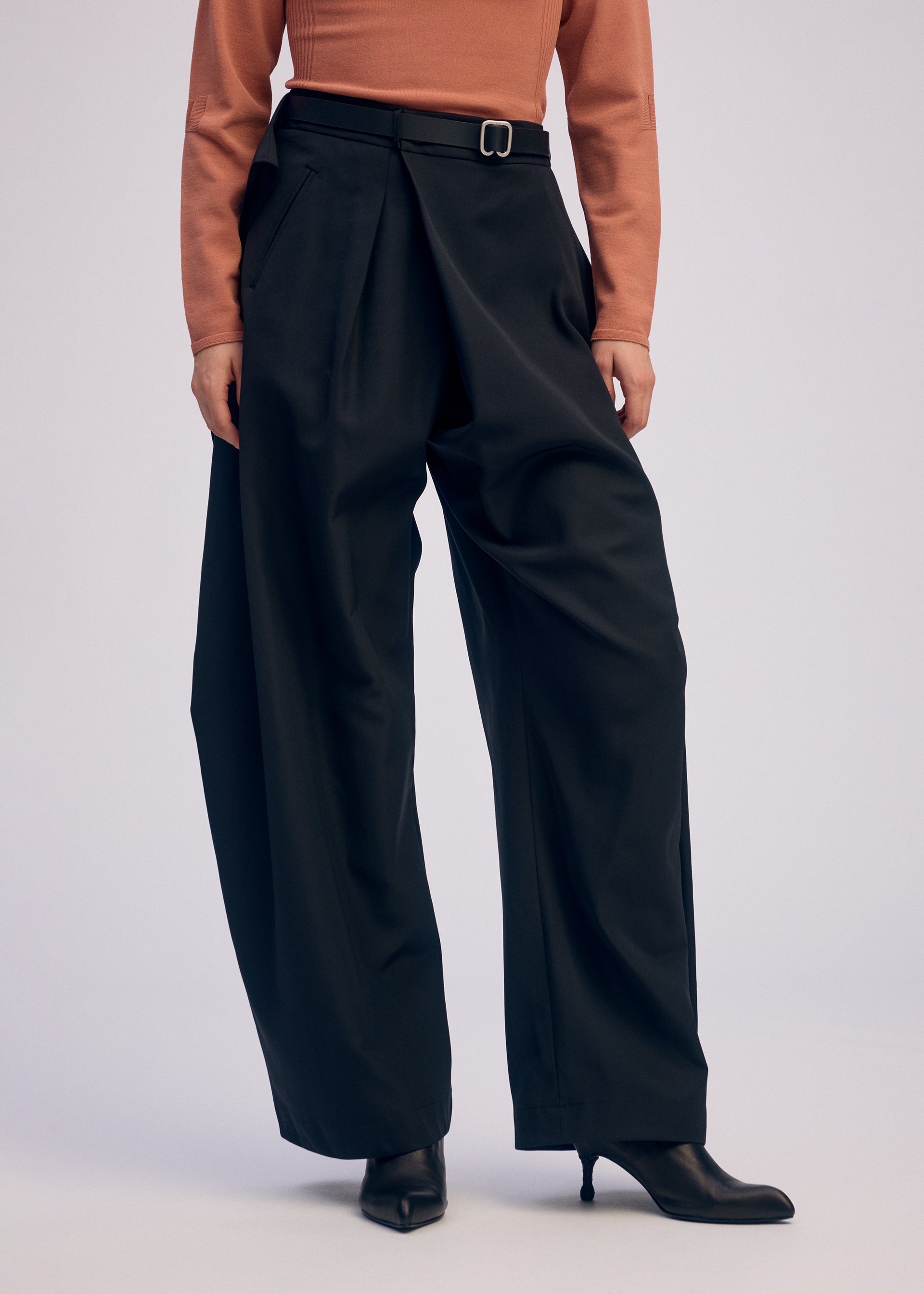 A model wears the ISSEY MIYAKE FLUTTERING PANTS pants.