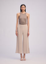 A model wears the Issey Miyake HATCHING BOTTOMS pants.
