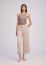 A model wears the Issey Miyake HATCHING BOTTOMS pants.