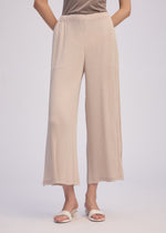 A model wears the Issey Miyake HATCHING BOTTOMS pants.
