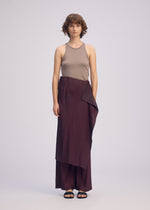 A model wears the ISSEY MIYAKE PLEATED ON PLEATS pants.