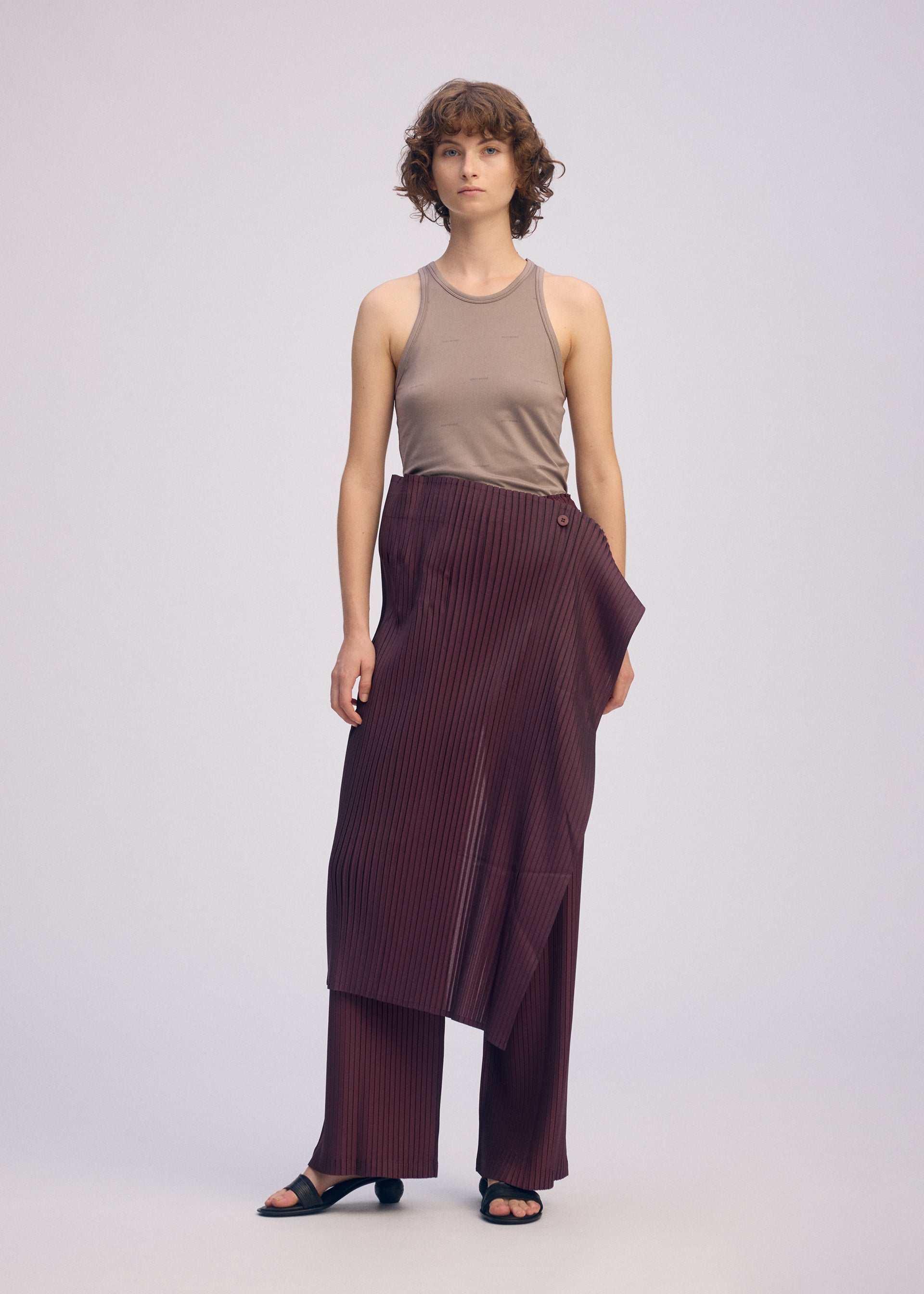 A model wears the ISSEY MIYAKE PLEATED ON PLEATS pants.