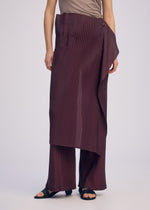 A model wears the ISSEY MIYAKE PLEATED ON PLEATS pants.