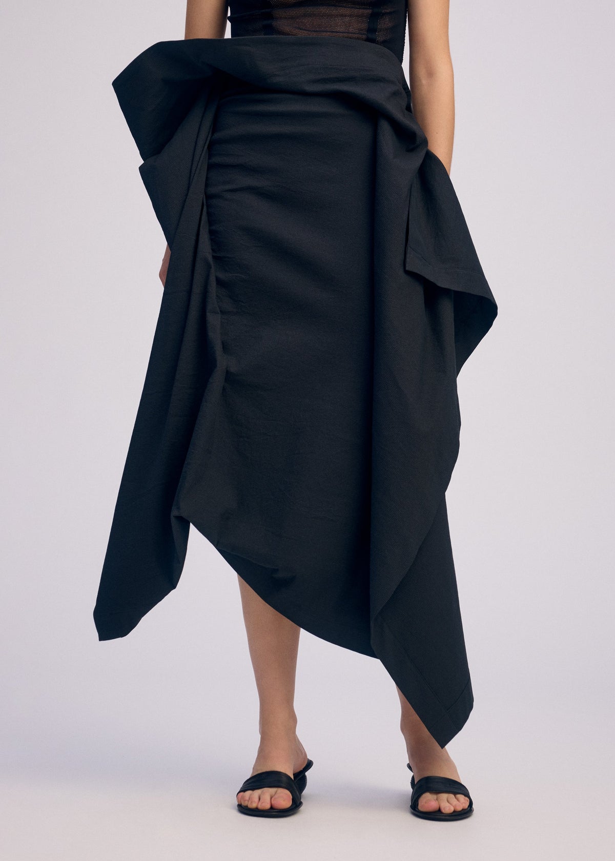 A model wears the ISSEY MIYAKE CONCEALED skirt.