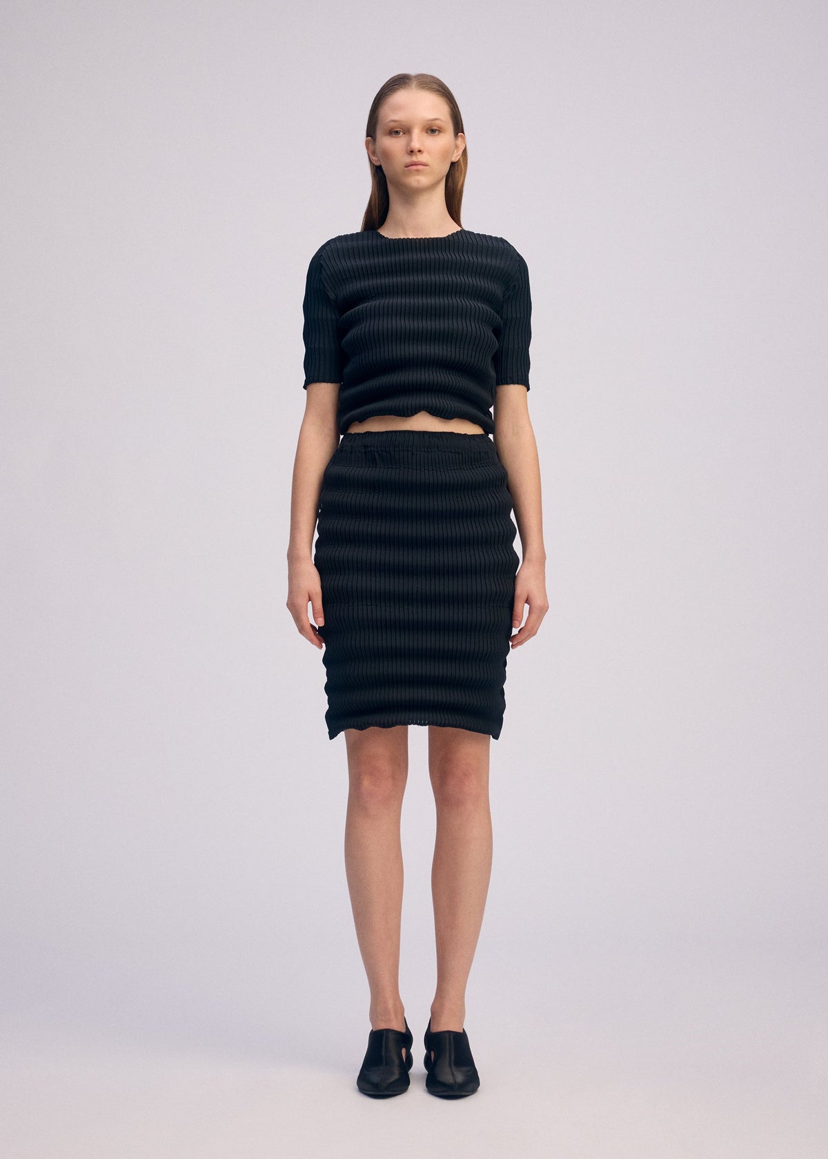A model wears the ISSEY MIYAKE SPRING PLEATS spring-pleats-skirt-starling-blue.
