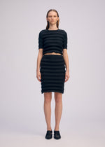 A model wears the ISSEY MIYAKE SPRING PLEATS spring-pleats-skirt-starling-blue.