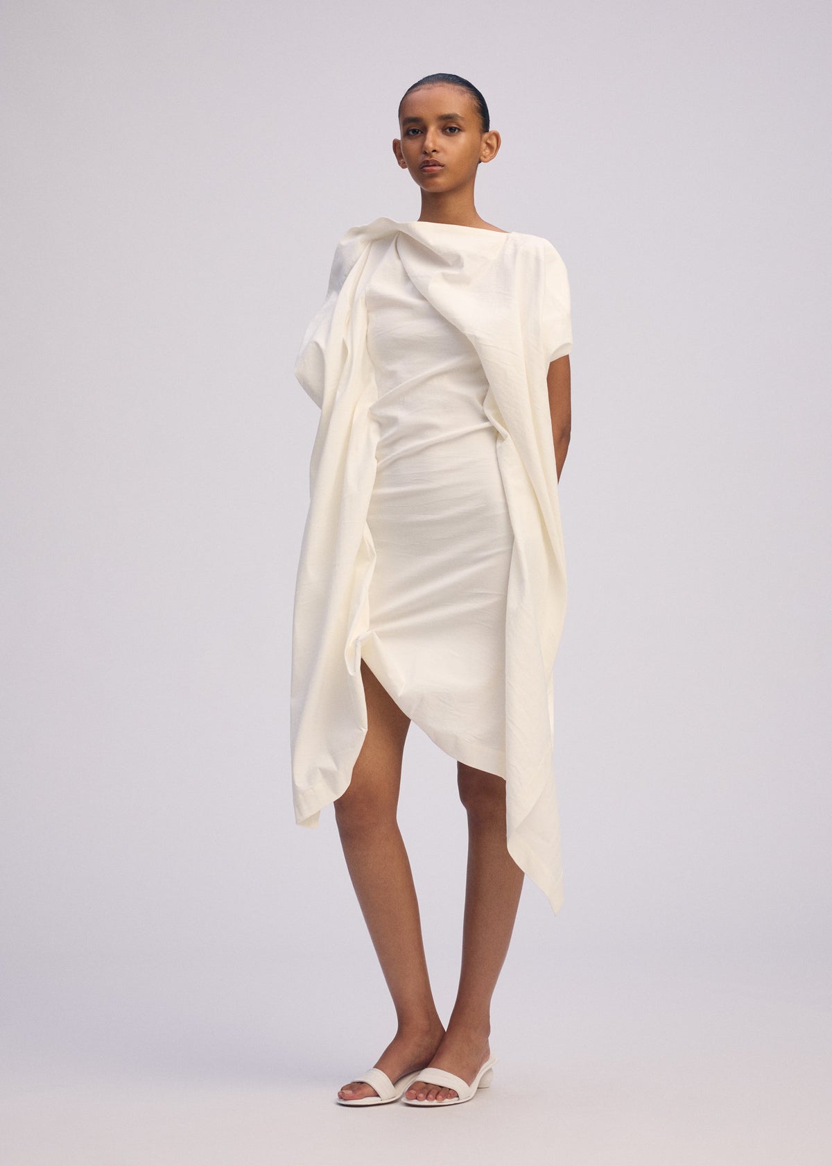 A model wears the ISSEY MIYAKE CONCEALED concealed-dress-white.
