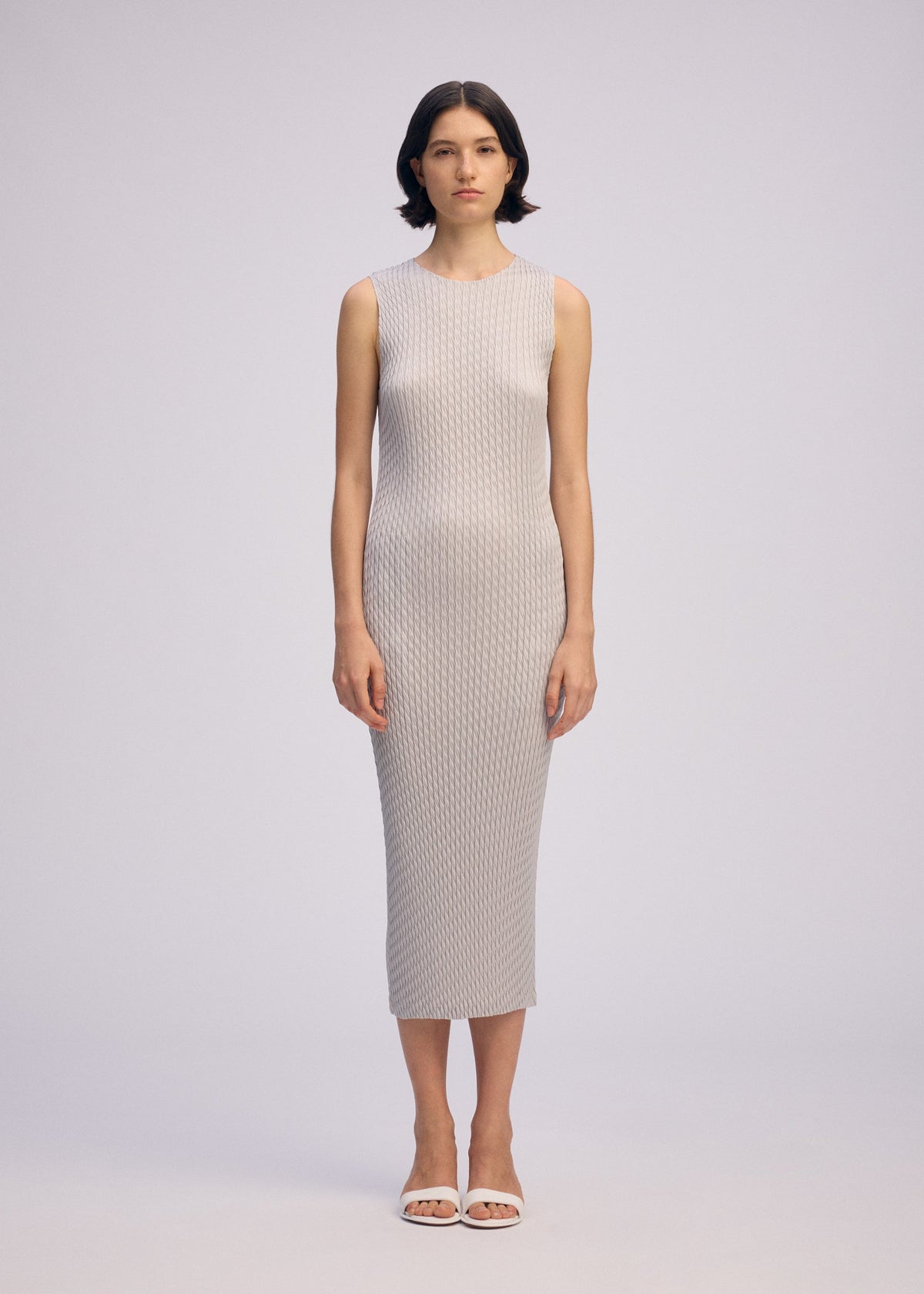 A model wears the ISSEY MIYAKE SLEEK PLEATS sleek-pleats-dress-black-2.