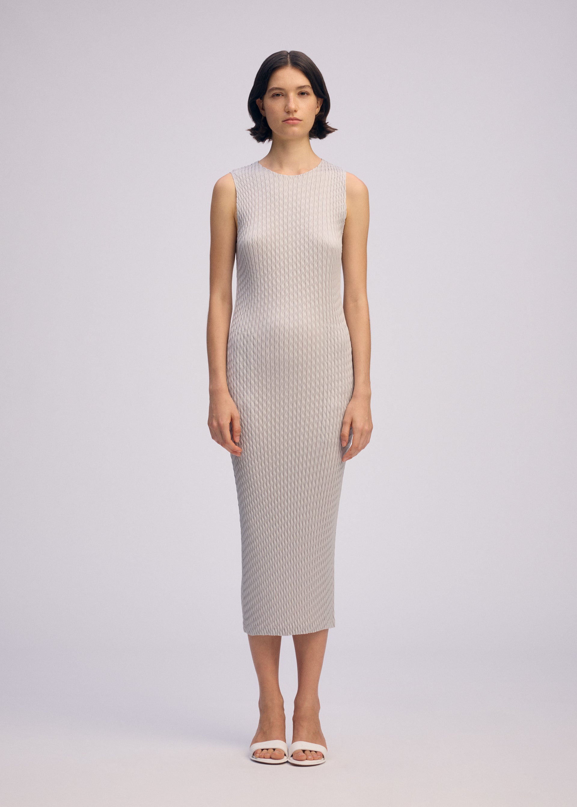 A model wears the ISSEY MIYAKE SLEEK PLEATS sleek-pleats-dress-burgundy.