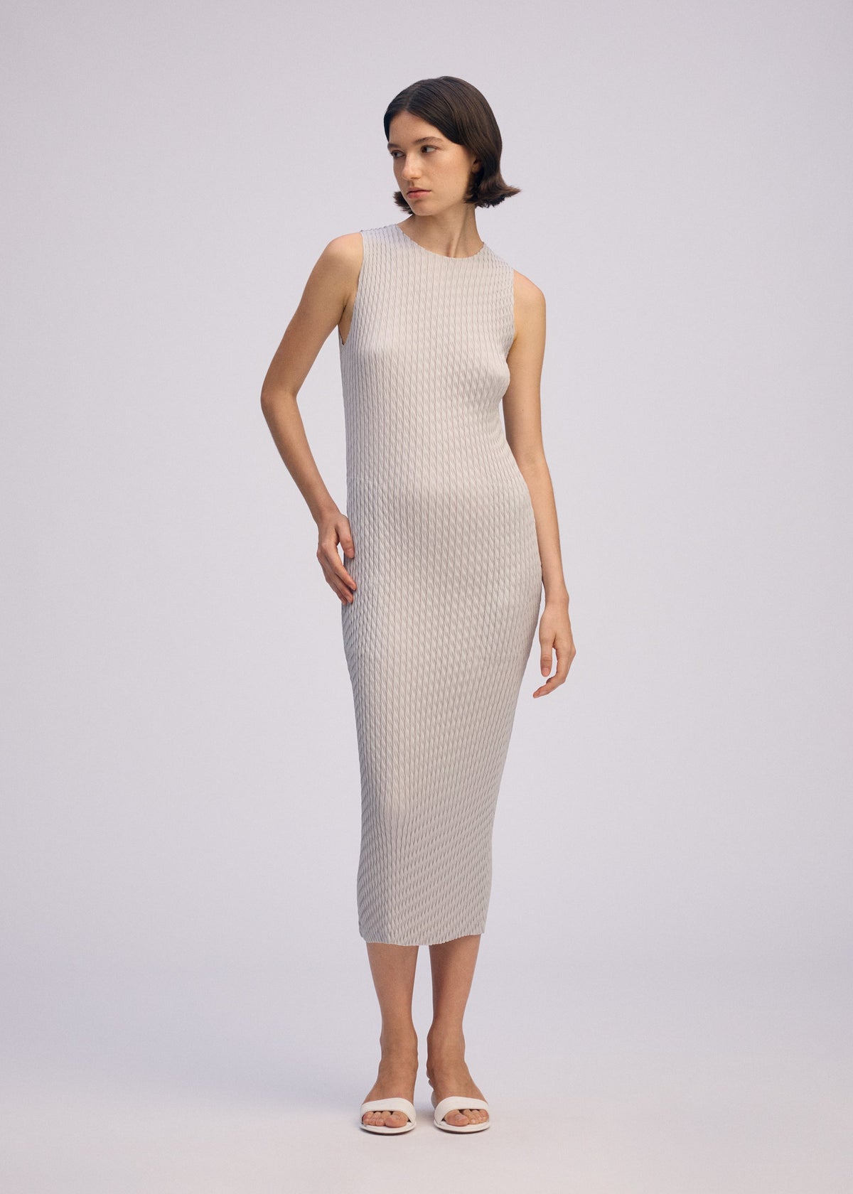 A model wears the ISSEY MIYAKE SLEEK PLEATS sleek-pleats-dress-black-2.