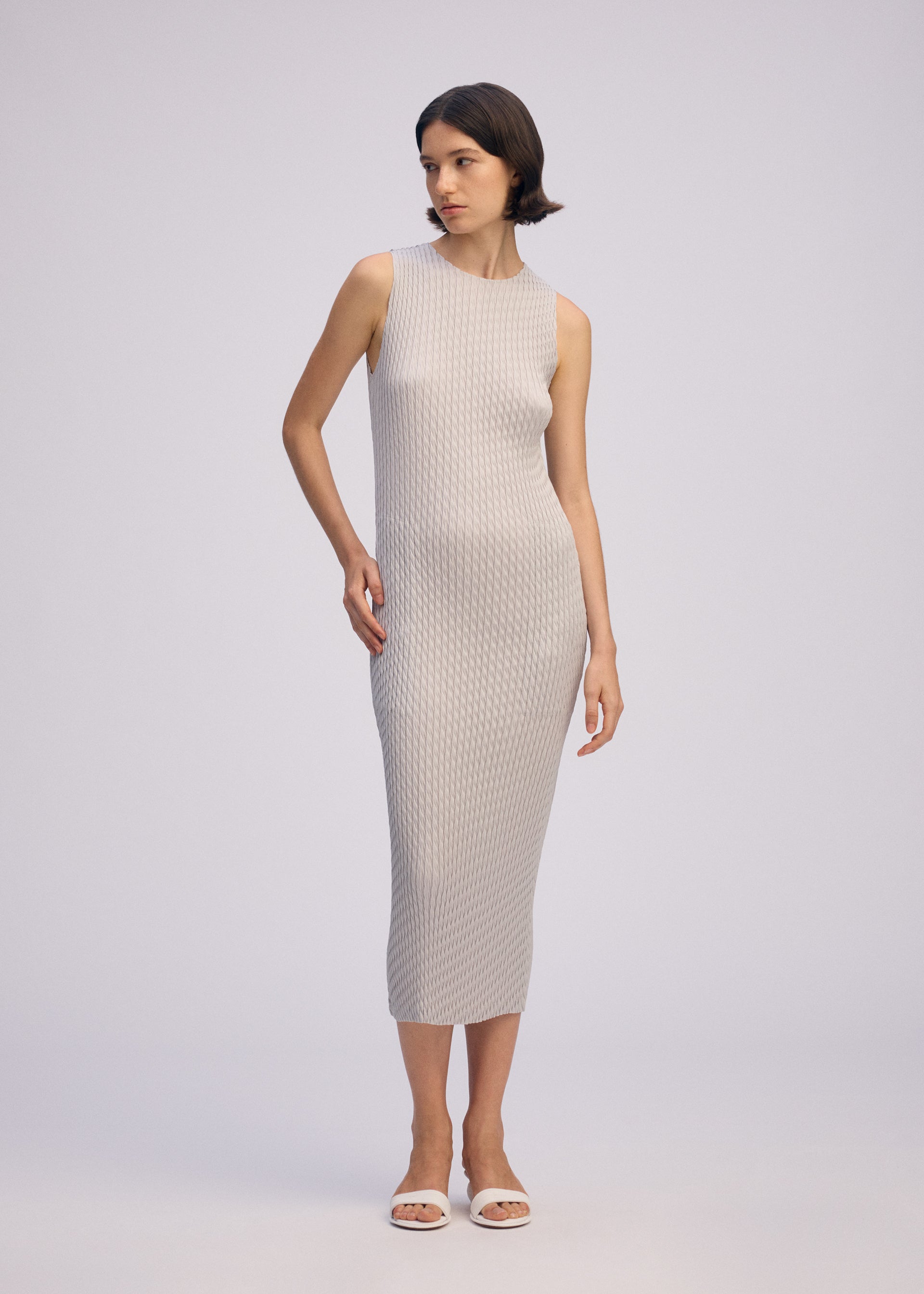 A model wears the ISSEY MIYAKE SLEEK PLEATS sleek-pleats-dress-burgundy.