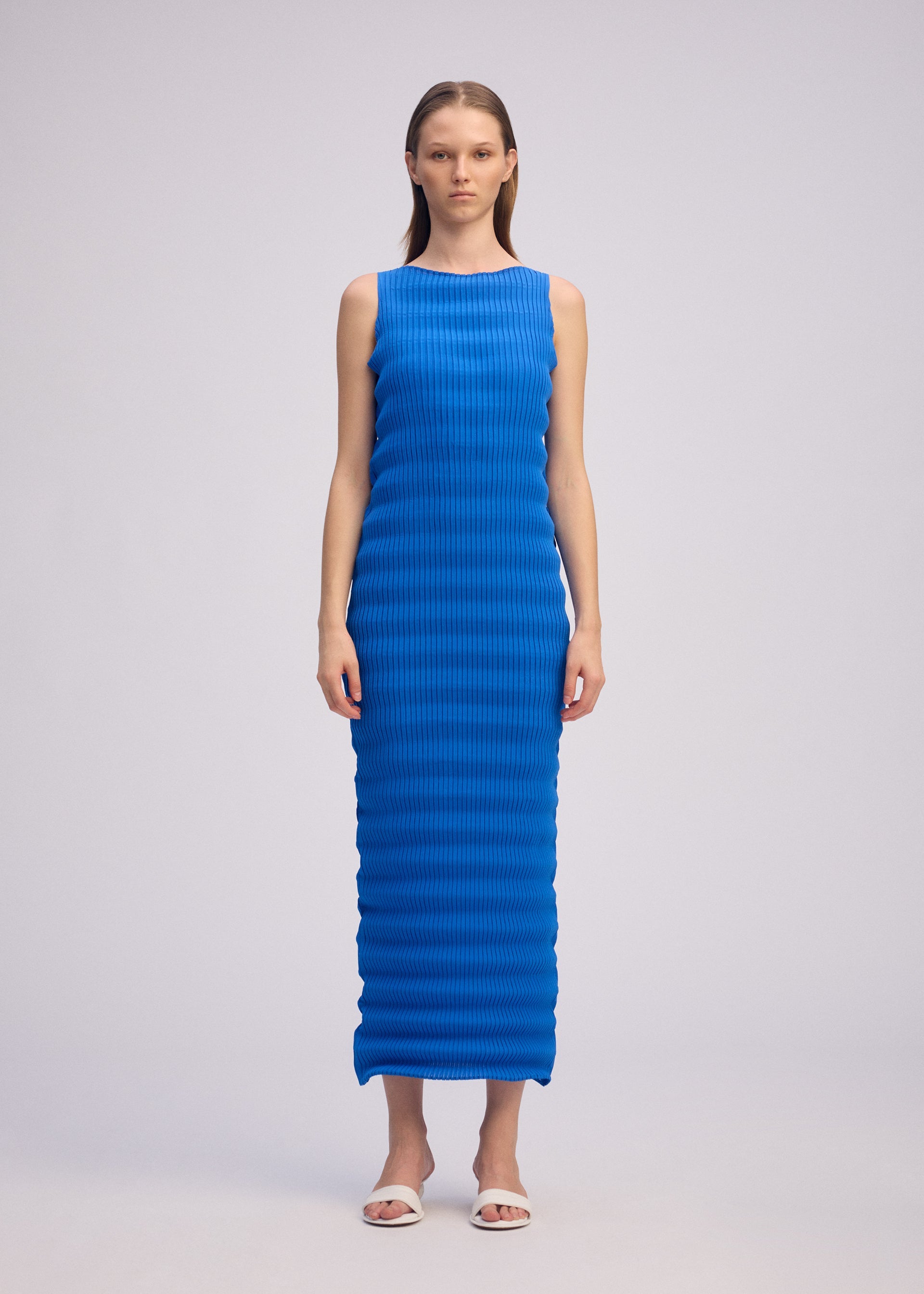 A model wears the ISSEY MIYAKE SPRING PLEATS spring-pleats-dress-chukar-beige-1.