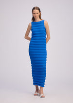 A model wears the ISSEY MIYAKE SPRING PLEATS spring-pleats-dress-chukar-beige-1.